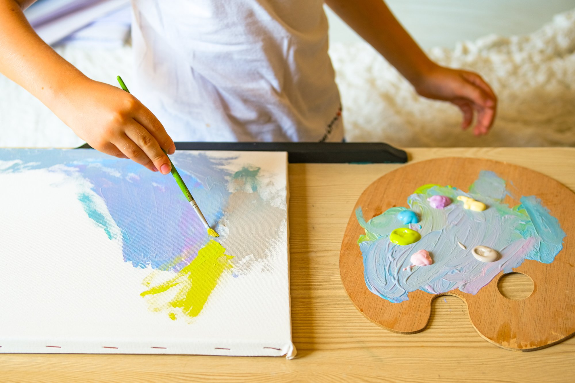 Child Painting on Canvas with Acrilic Paint.